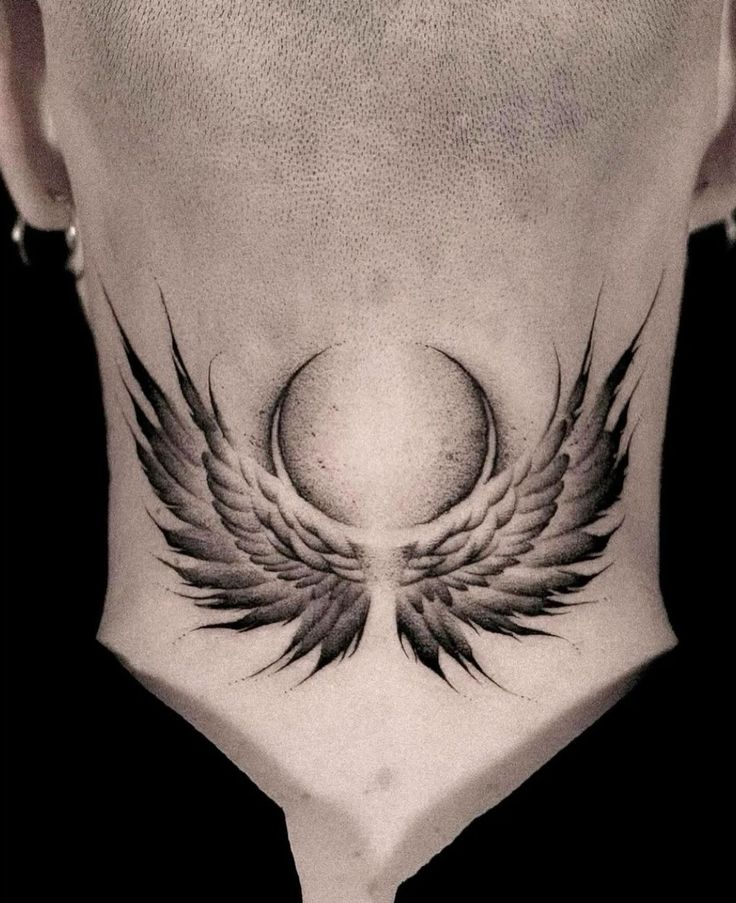 a man's neck with an angel wing tattoo on it