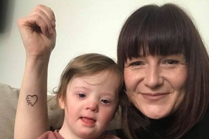 a woman and her daughter are smiling for the camera while they both have tattoos on their arms