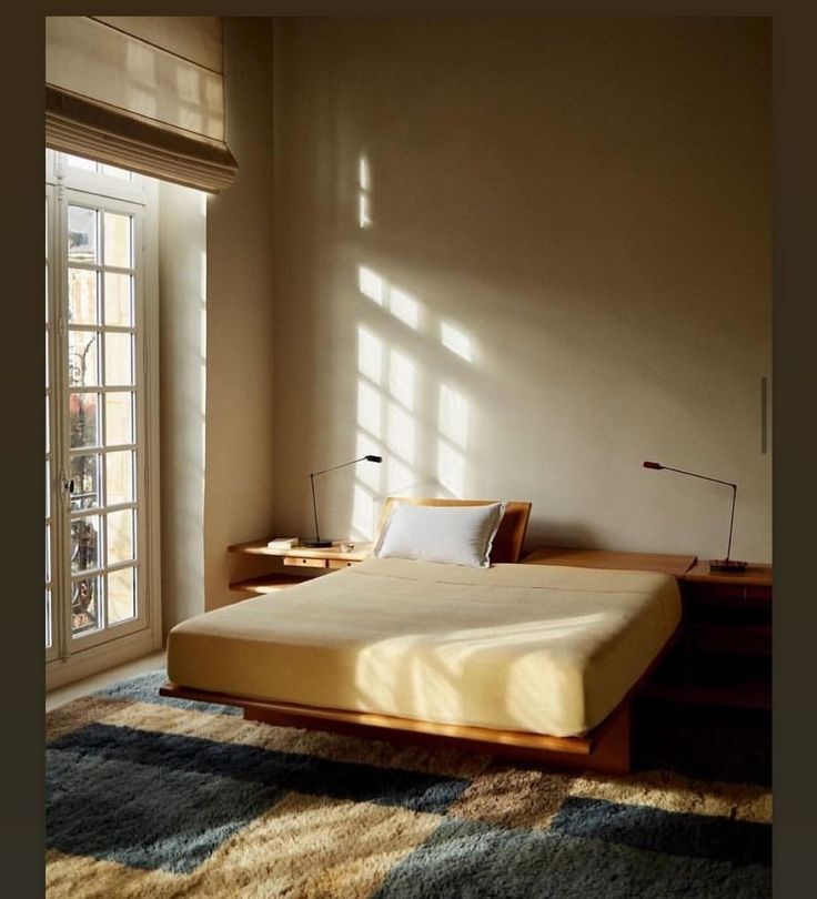 a bed sitting next to a window in a bedroom