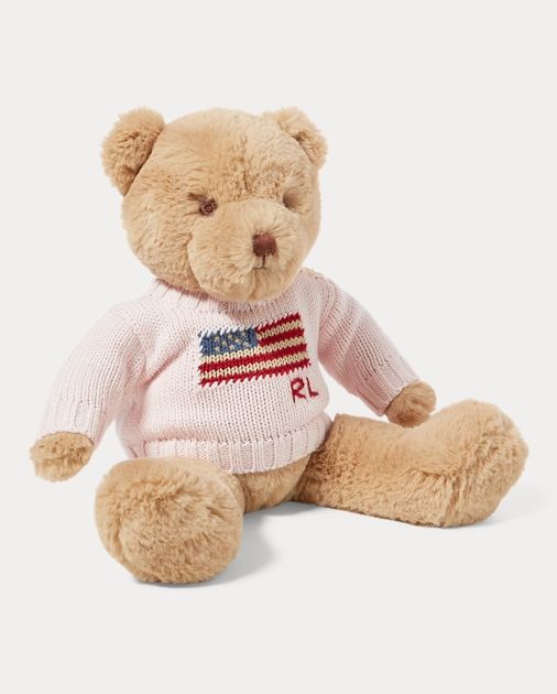 a teddy bear wearing a sweater and sitting down