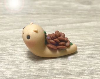 a small figurine of a snail with nuts on it's back sitting on a table