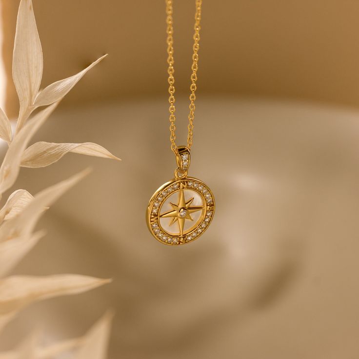 Perfect for summer, our Pave Pearl Compass Necklace features a stunning Mother of Pearl Center and a sparkling Pave Gemstone Rim with a compass in the middle, adding a touch of nautical charm and luminous elegance to any outfit. It's the ideal accessory for sunny days and breezy evenings! SKU: RR-NR225 Product Details Material: High Quality Solid 925 Sterling Silver Finish: 18K Gold ∙ Sterling Silver Featuring a ~15mm Mother of Pearl Compass Pendant with CZ Diamond Gemstones on a dainty Cable Ch Compass Pendant Necklace, Compass Jewelry, Compass Pendant, A Compass, Compass Necklace, Cz Diamond, Birthstone Ring, Diamond Gemstone, Name Necklace