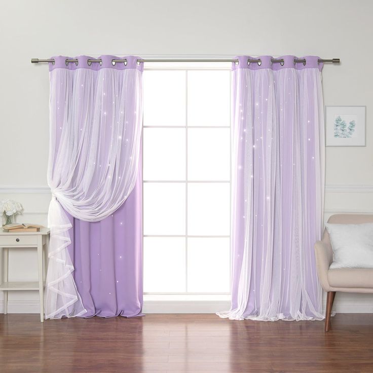 a living room filled with furniture and a window covered in purple drapes next to a white chair