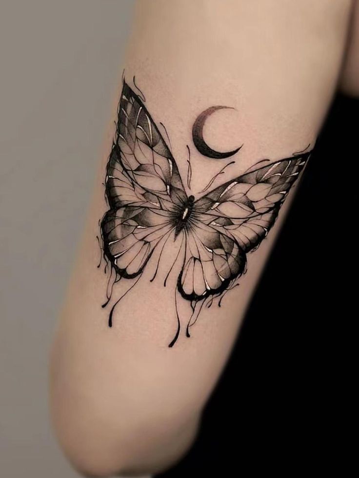 a woman's arm with a black and white butterfly tattoo on the left side