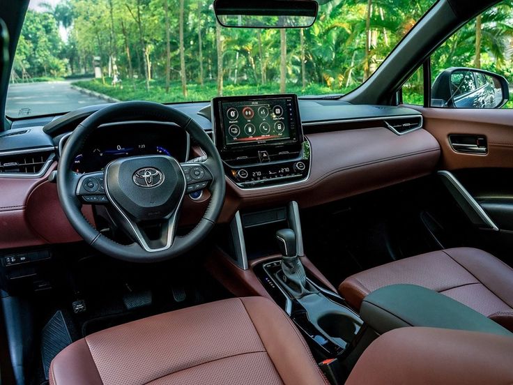 the interior of a car with brown leather seats and steering wheel, along with dashboard controls