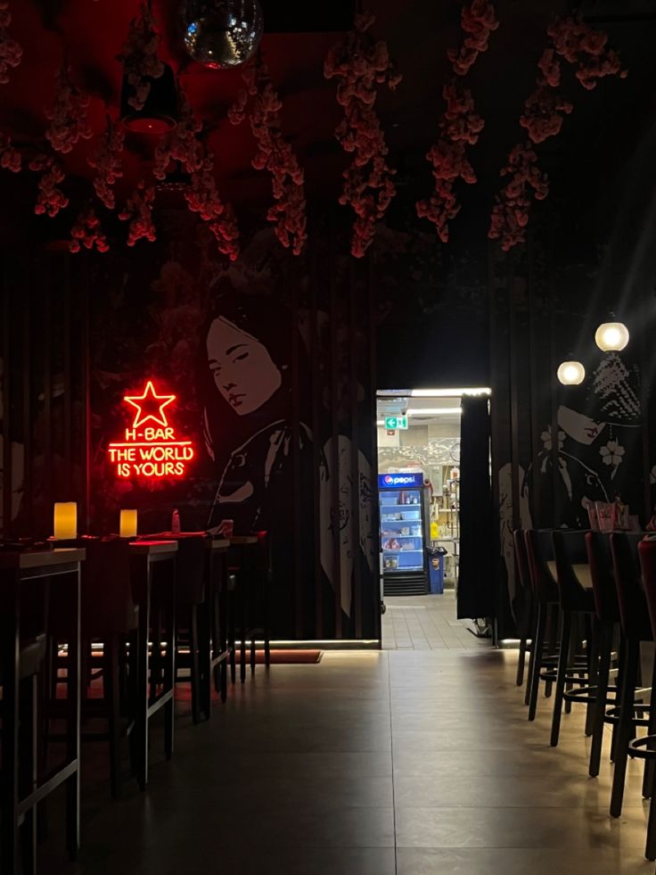 an empty restaurant with red lighting and chairs