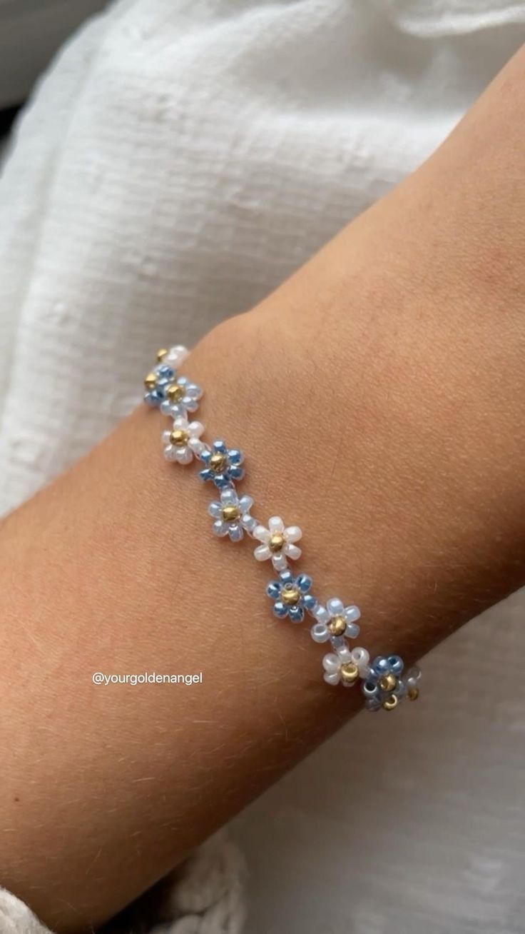 a woman's arm with a blue and white beaded bracelet on it