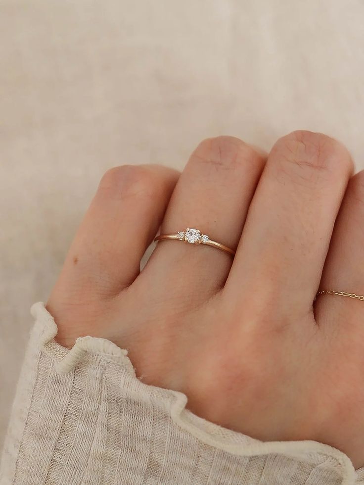 a woman's hand with a diamond ring on it