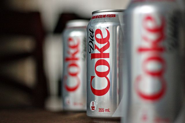 several cans of coke are lined up on a table