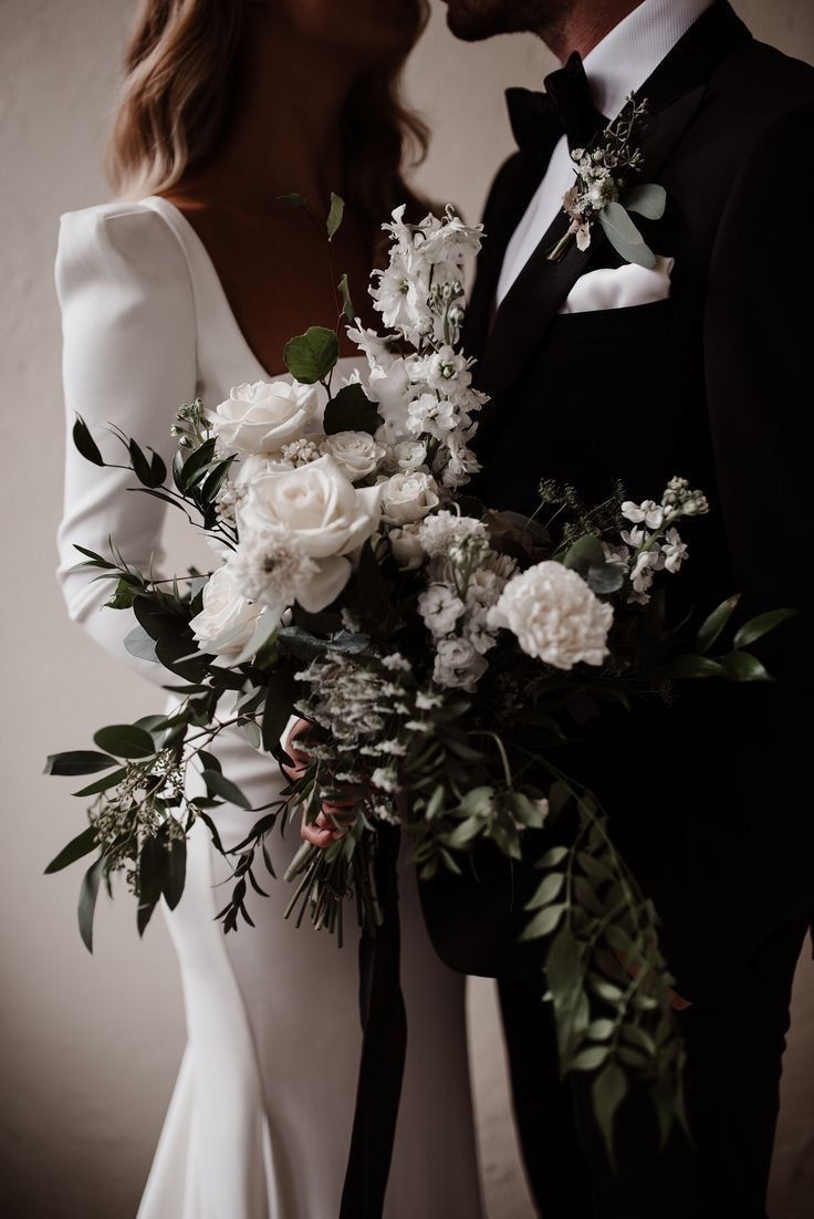 the bride and groom are holding their bouquets