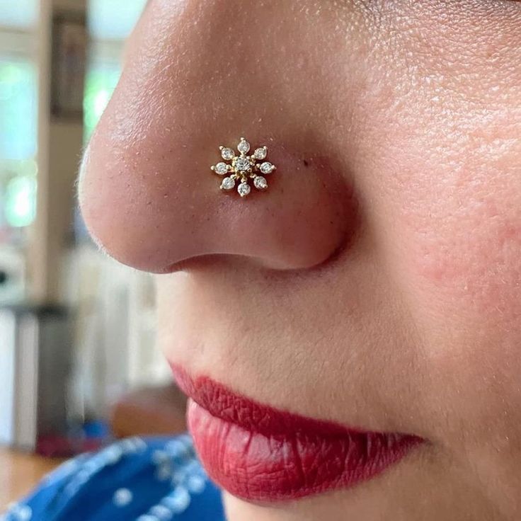 a close up of a person with a nose ring on their nose and a flower in the middle