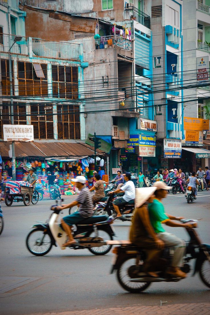 several people riding motorcycles on a city street