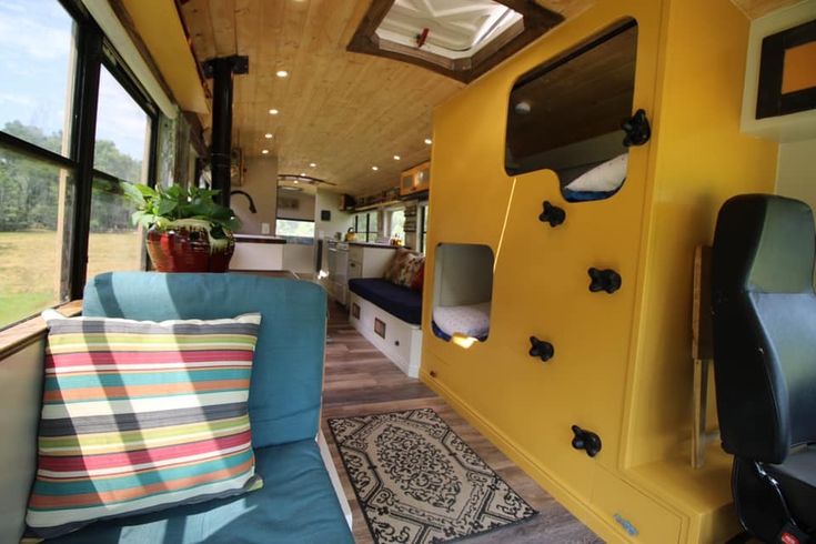 the interior of a bus with yellow walls and blue couches in front of it