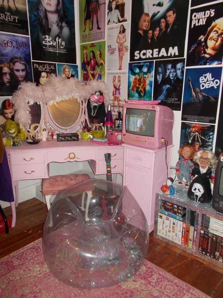 a bedroom with pink furniture and posters on the wall