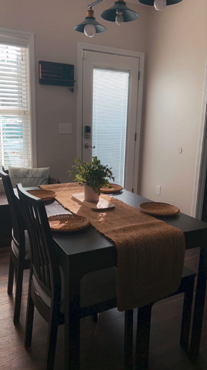 a dining room table with place mats and plates on it in front of the door