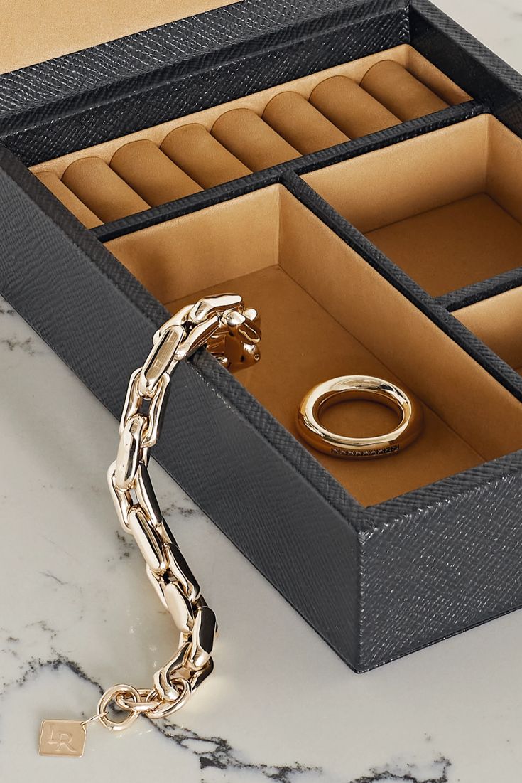 Smythson's 'Panama' jewelry box has been beautifully handcrafted in Spain from the label's textured-leather that's stamped with the logo in gold lettering. It opens to a soft nubuck interior with three compartments and seven ring slots to keep your collection free from secure and organized. Minimalist Rectangular Leather Jewelry, Chic Leather Jewelry For Evening, Rectangular Leather Jewelry For Business, Luxury Black Jewelry For Office, Luxury Black Office Jewelry, Black Rectangular Leather Jewelry, Luxury Formal Jewelry Storage Box, Black Leather Rectangular Jewelry, Luxury Leather Rectangular Jewelry