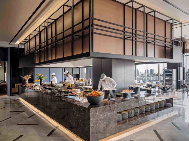 a restaurant with chefs preparing food on the counter and in front of them is a large window