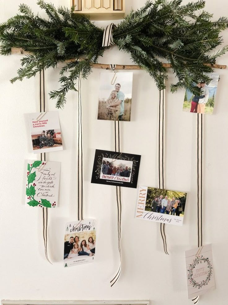 a bunch of pictures hanging on a wall with christmas cards attached to the pegs