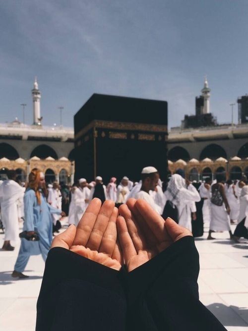 two hands folded in front of a large group of people standing around the kabab