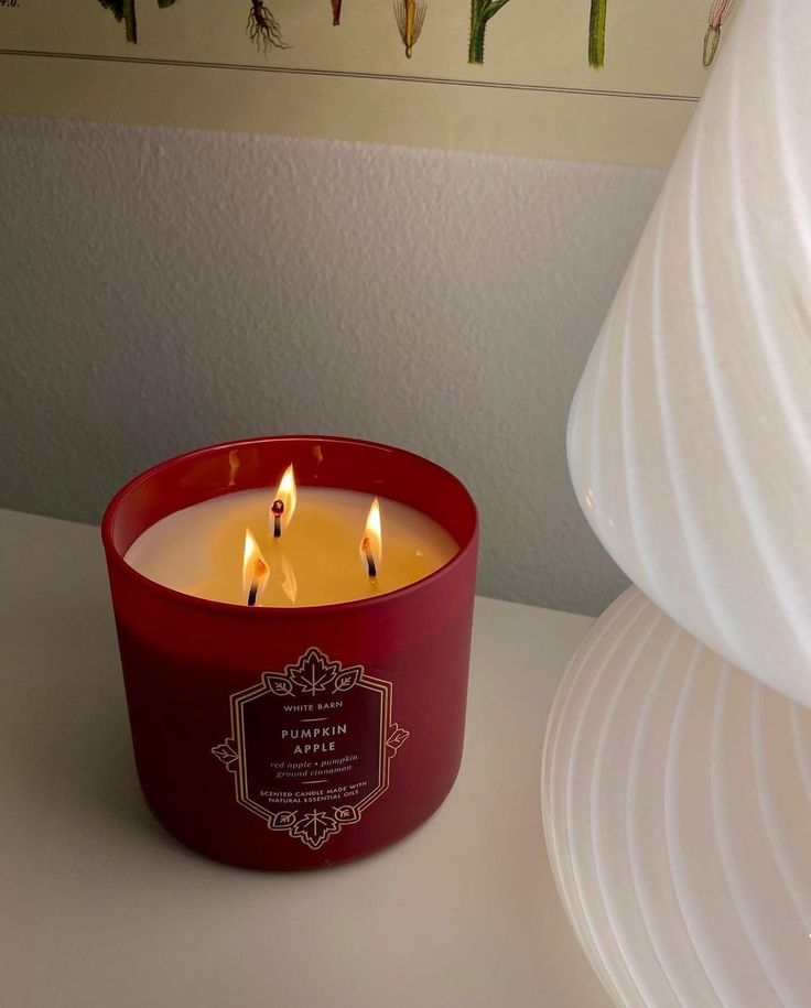 a red candle sitting on top of a white table