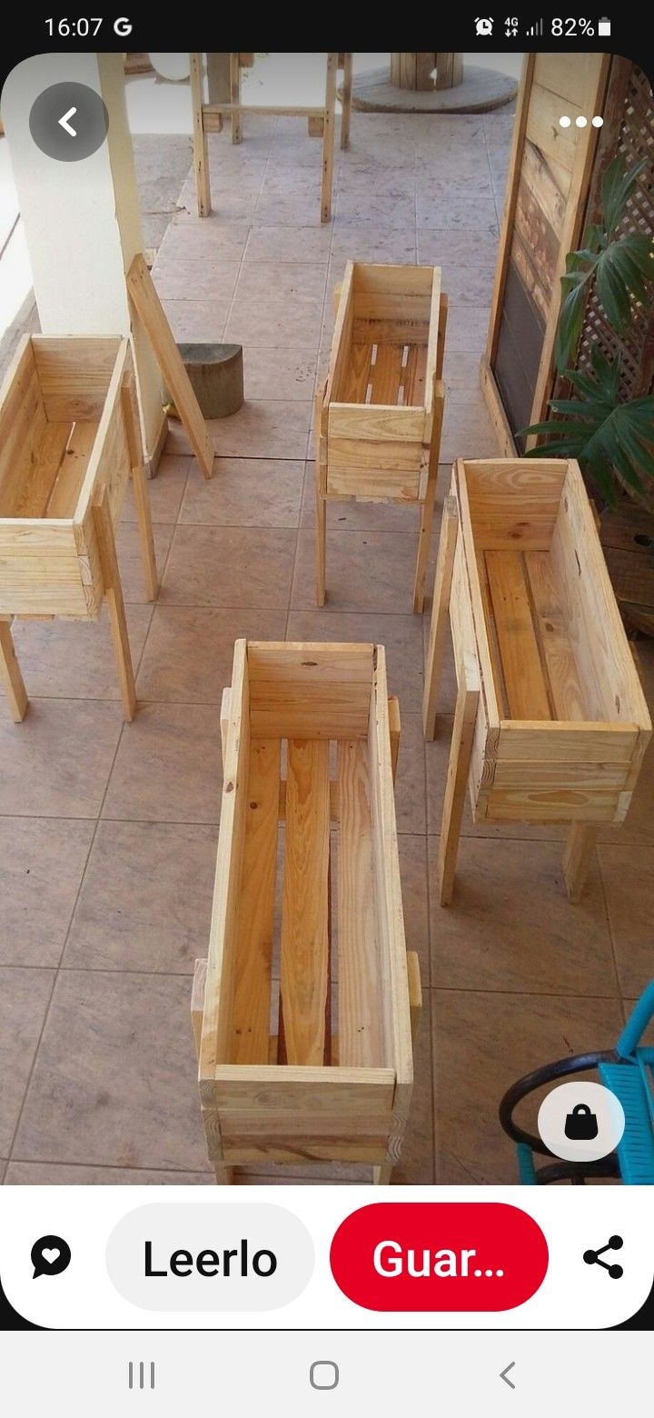 four wooden benches sitting on top of a tile floor next to a blue chair and potted planter