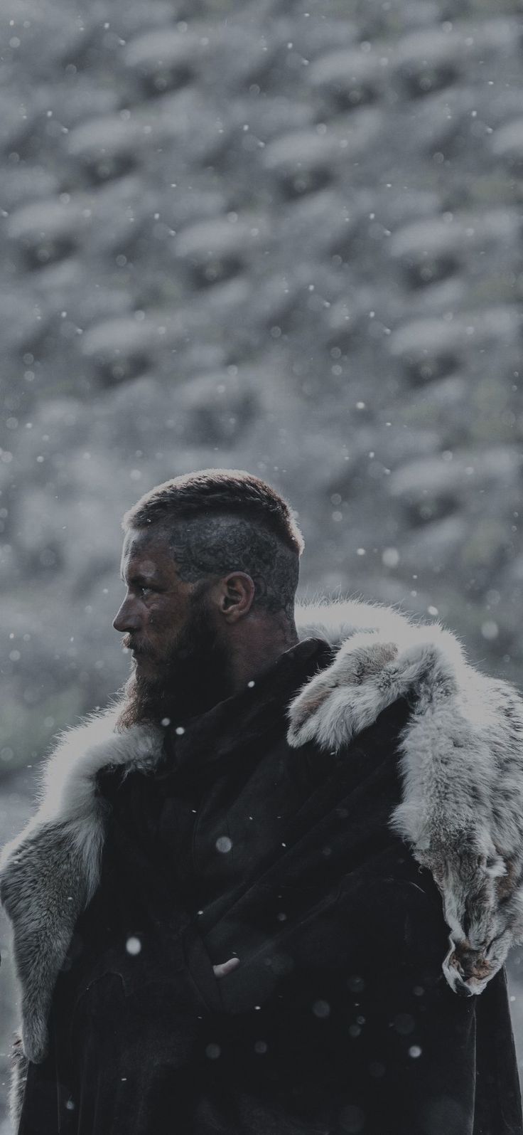 a man standing in the snow wearing a black coat