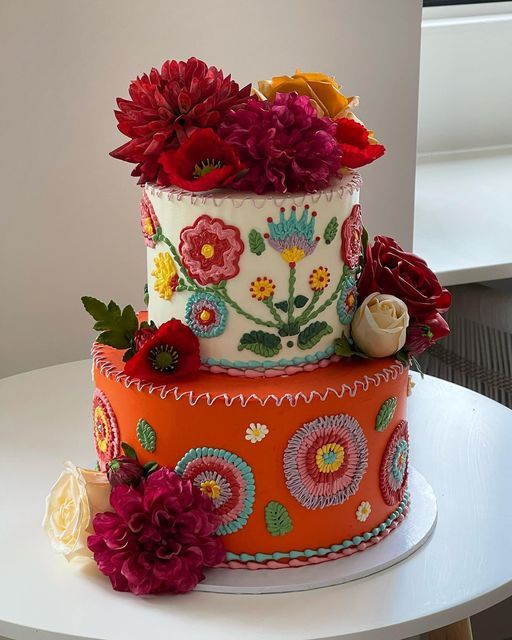 a multi - tiered cake decorated with flowers on a table