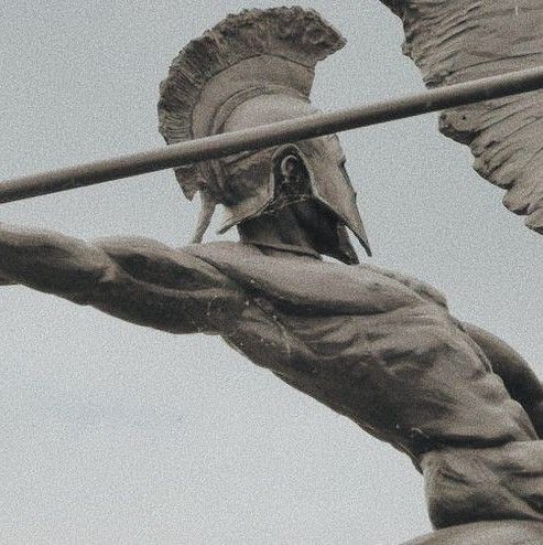 a statue of a man holding a pole with wings on it's head and arm