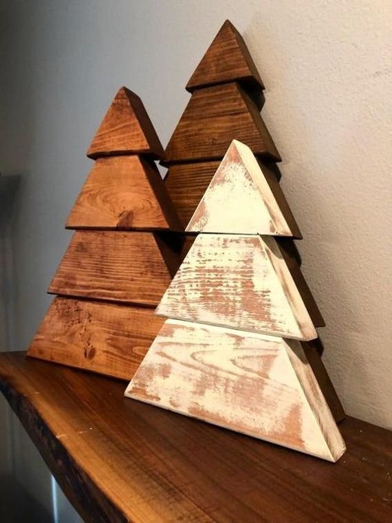 three wooden christmas trees sitting on top of a table