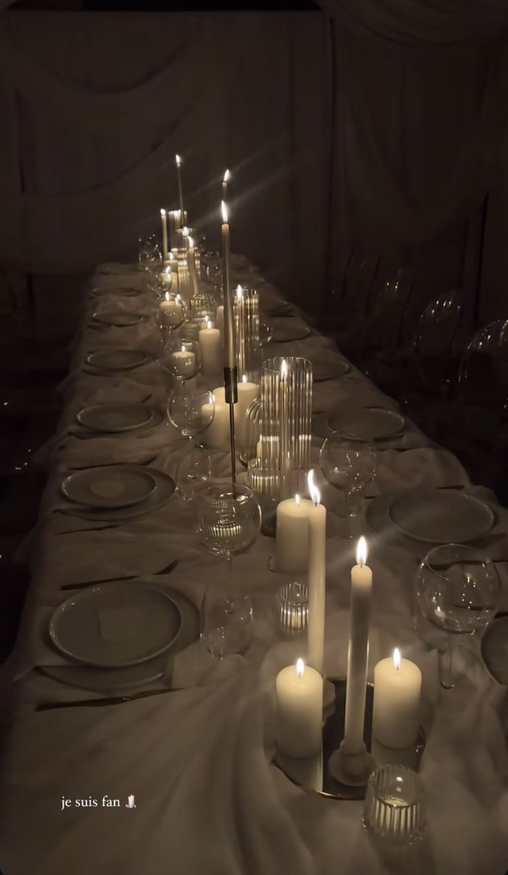 a long table is set with candles and plates for dinner guests to enjoy the night