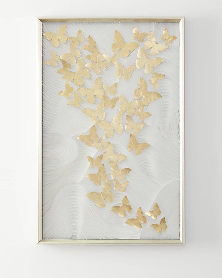 a white and gold framed artwork with butterflies on the wall in an art gallery or office space