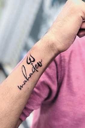 a man with a wrist tattoo that says, whatever is under control on his arm