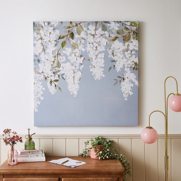 a painting hanging on the wall above a wooden table