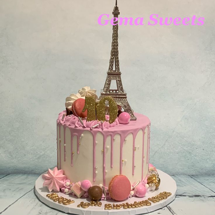 a pink and white cake with the eiffel tower in the background