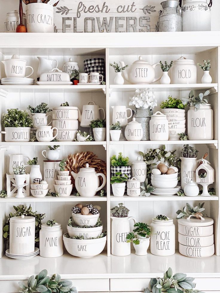 a white shelf filled with lots of dishes and cups on top of it's shelves