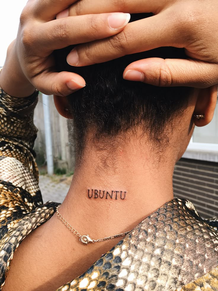 a woman with a tattoo that reads ubuntu on her neck