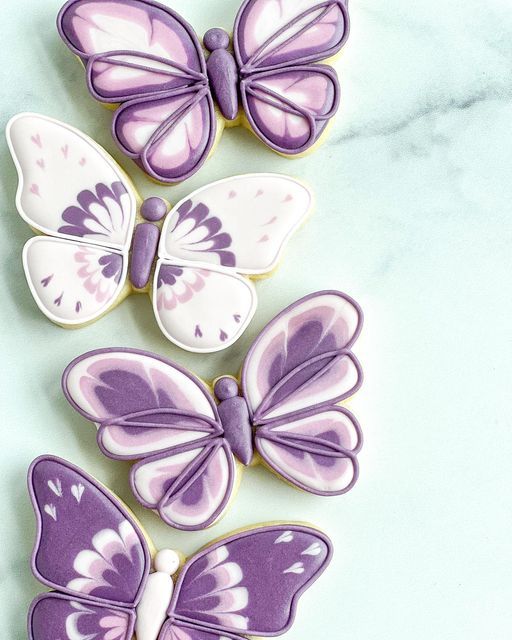 purple and white butterfly cookies on a marble counter top with the words, how to decorate butterflies