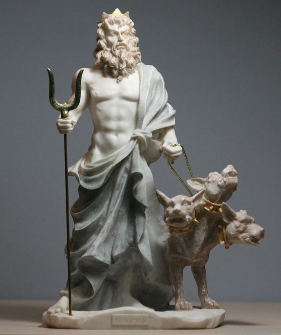 a statue of an old man holding a staff with two dogs in front of him