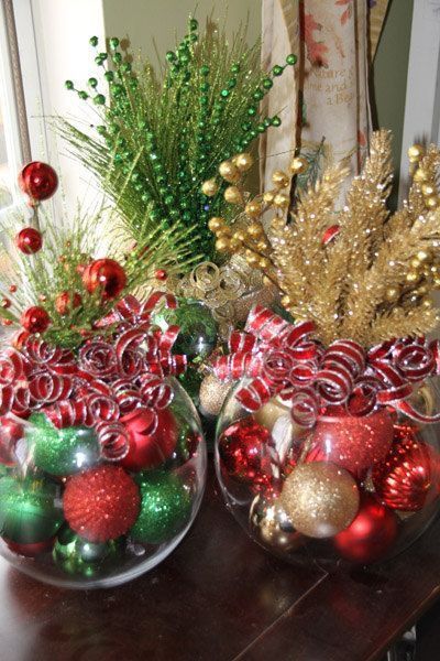 two glass bowls filled with ornaments on top of a table