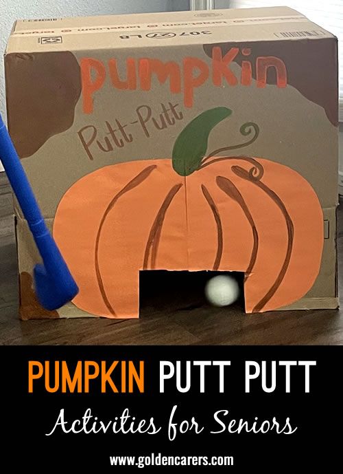 a cardboard box with a pumpkin cut out in it and a blue plastic baseball bat