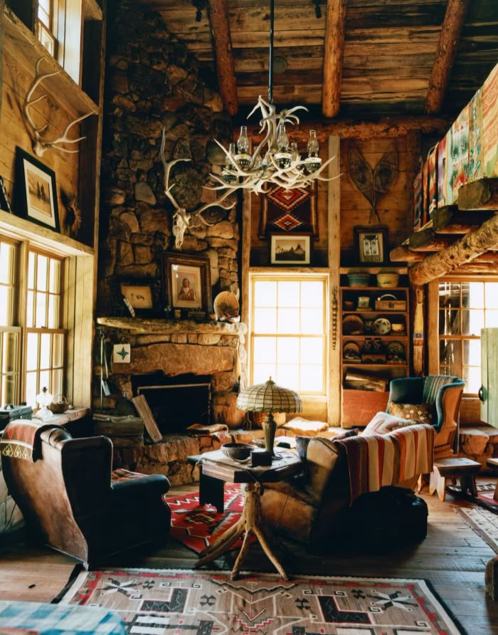 a living room filled with furniture and a chandelier hanging from the ceiling over a fire place