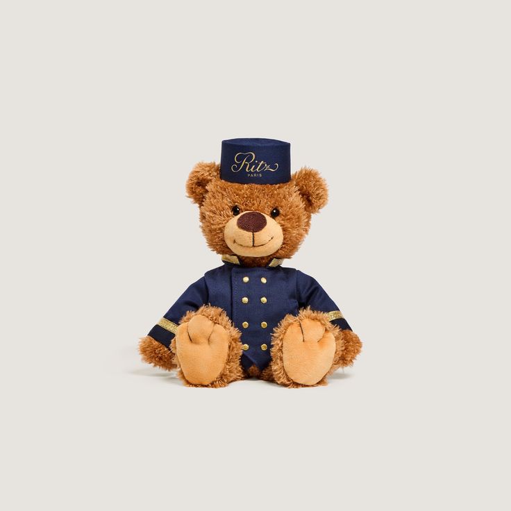 a brown teddy bear wearing a blue uniform