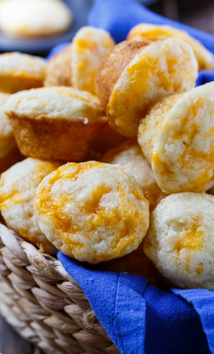 a basket filled with yellow and white pastries on top of a blue cloth covered table