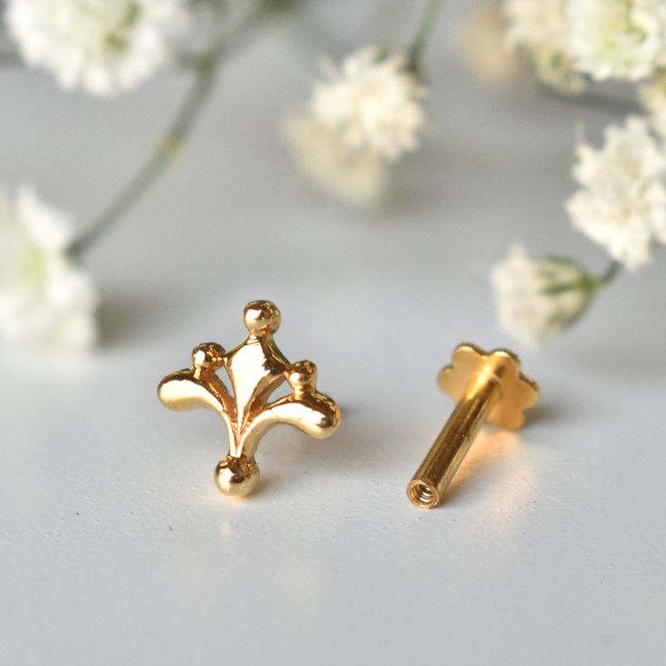 "Inspired from the beautiful Mughal motifs, this gold floral stud is a perfect piece for all your piercings. Crafted in 14k solid gold, this one of a kind pin makes for a great gift for a piercing lover and your loved ones. Great for your tragus, lobe, conch, helix, flat piercing. It also makes for a mesmerizing nose jewelry. * Dimension : 7x7mm (approx.) * Material : 14k Solid Gold If you like this stud, please press \"Pin it\" button on the top of your screen. Follow us on Instagram : @abhikaj Mughal Motifs, Unique Nose Rings, Flat Piercing, Conch Piercing Jewelry, Diamond Nose Stud, Diamond Ear Cuff, Floral Studs, Nose Jewelry, Solid Gold Earrings