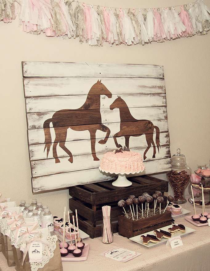 a table topped with cake and desserts next to a wooden sign that says horses