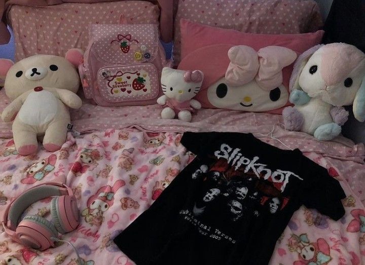 several stuffed animals sitting on top of a bed next to pillows and pillowcases