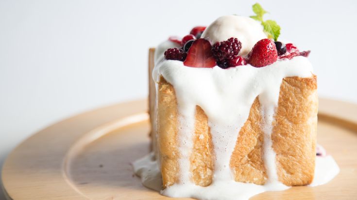 a piece of cake on a plate with white icing and berries in the middle