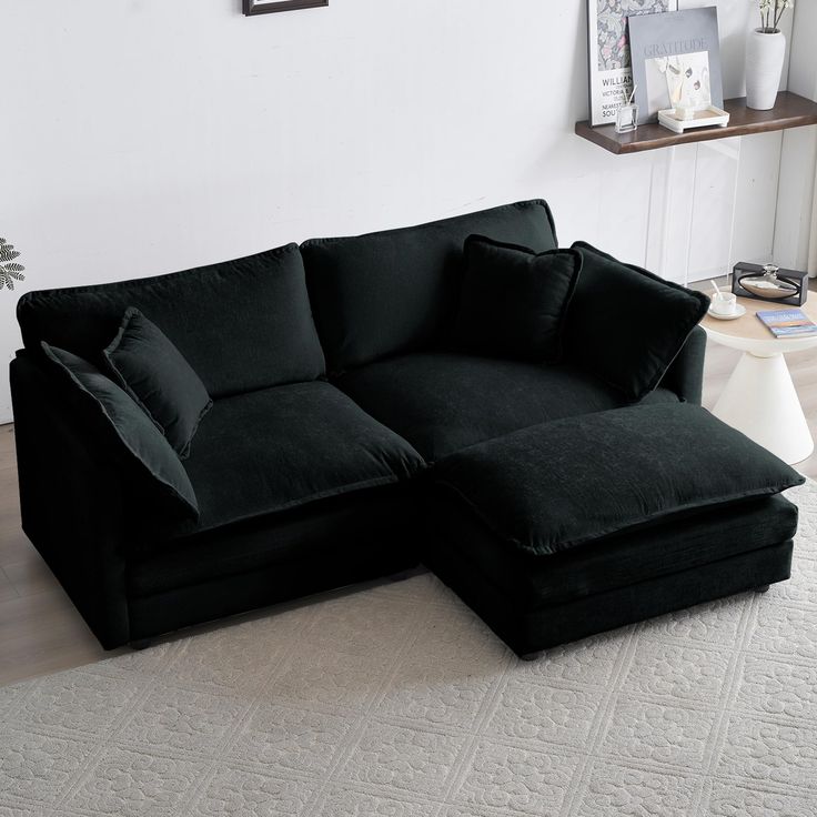 a large black couch sitting on top of a white rug