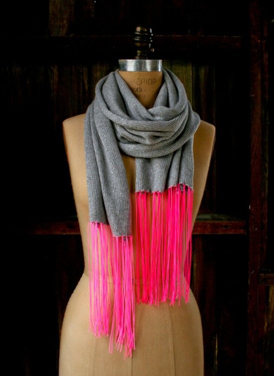 a mannequin wearing a scarf with pink and grey fringes on it's neck