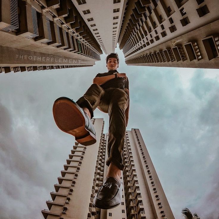 a man is doing tricks on his skateboard in front of high rise apartment buildings